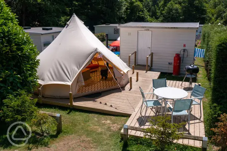 Ensuite bell tent with decking and outdoor furniture at Bluebell Coppice Park