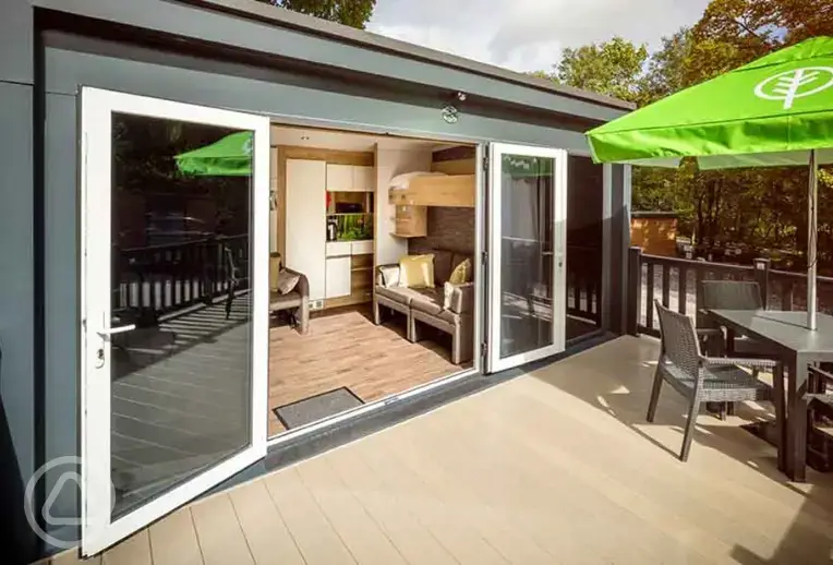 Glamping pod with an outdoor deck area and seating