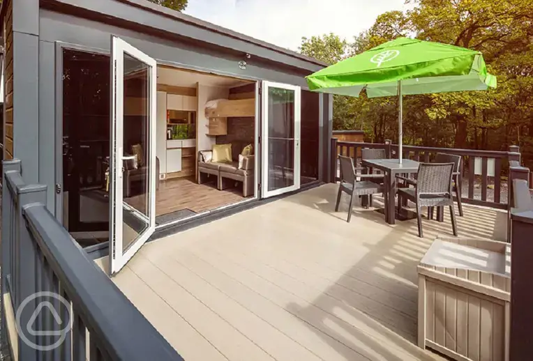 Glamping pod deck area with double glass doors and a box for muddy shoes