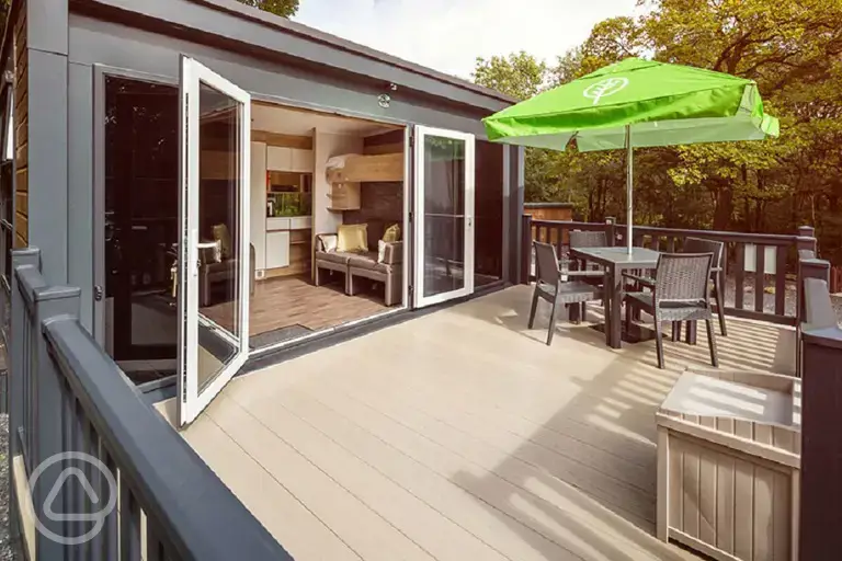 Glamping pod deck area with double glass doors and a box for muddy shoes