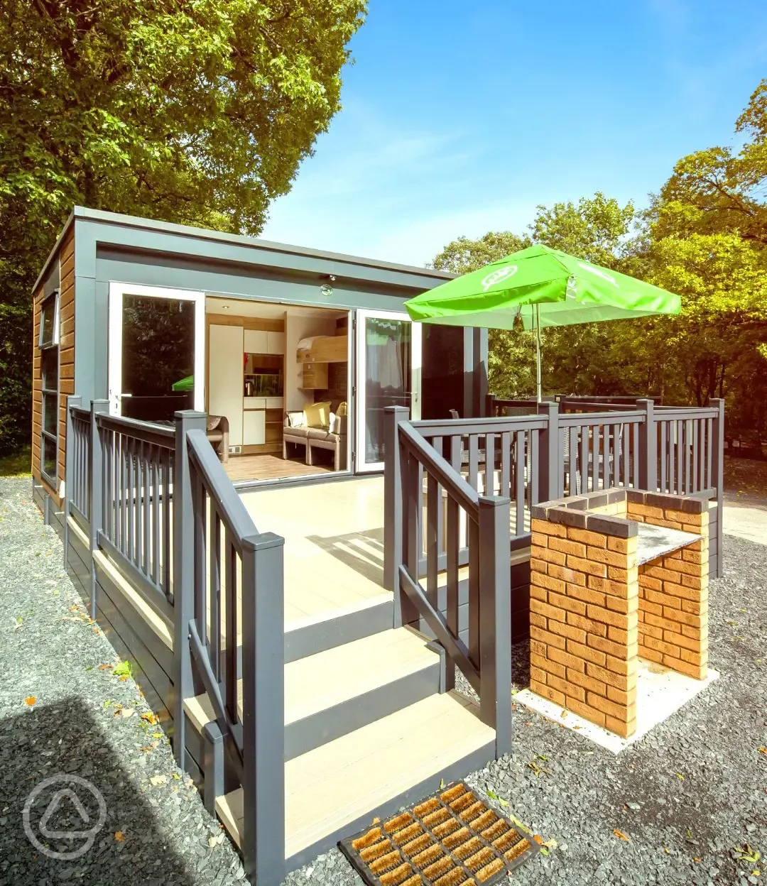 Ensuite glamping pods accessed by a small set of stairs with a brick BBQ