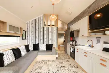 Ensuite glamping cabin interior with a sofa bed and mezzanine level