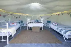 Yurt interior with a double bed and two singles (bedding provided) Yurt interior with a double bed and two singles (bedding provided)