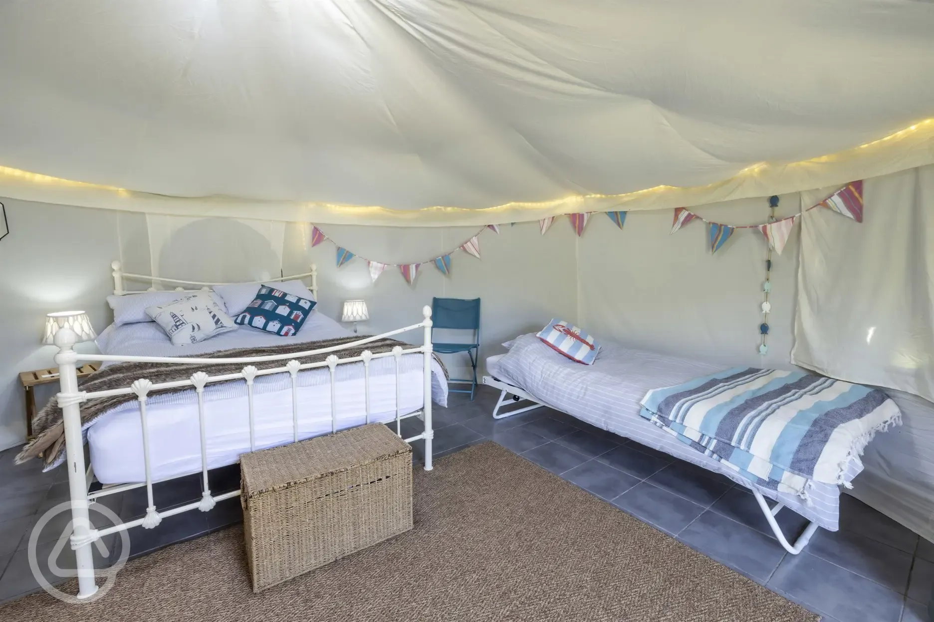 Yurt interior with a double bed and two singles (bedding provided)