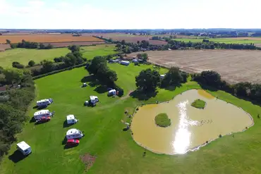 Aerial view of the electric grass touring pitches with a lake
