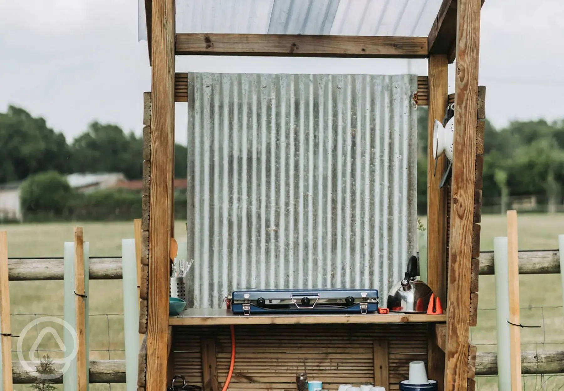 Bell tent camp kitchen with a gas stove, kettle and crockery