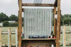 Bell tent camp kitchen with a gas stove, kettle and crockery