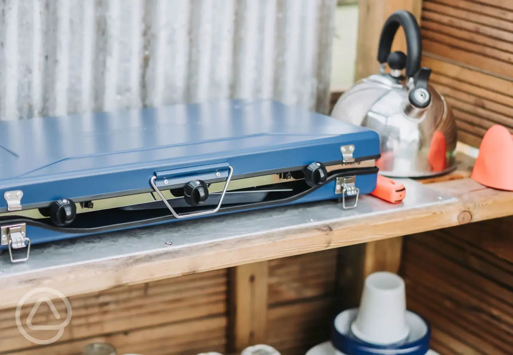 Bell tent camp kitchen with a gas stove, kettle and crockery