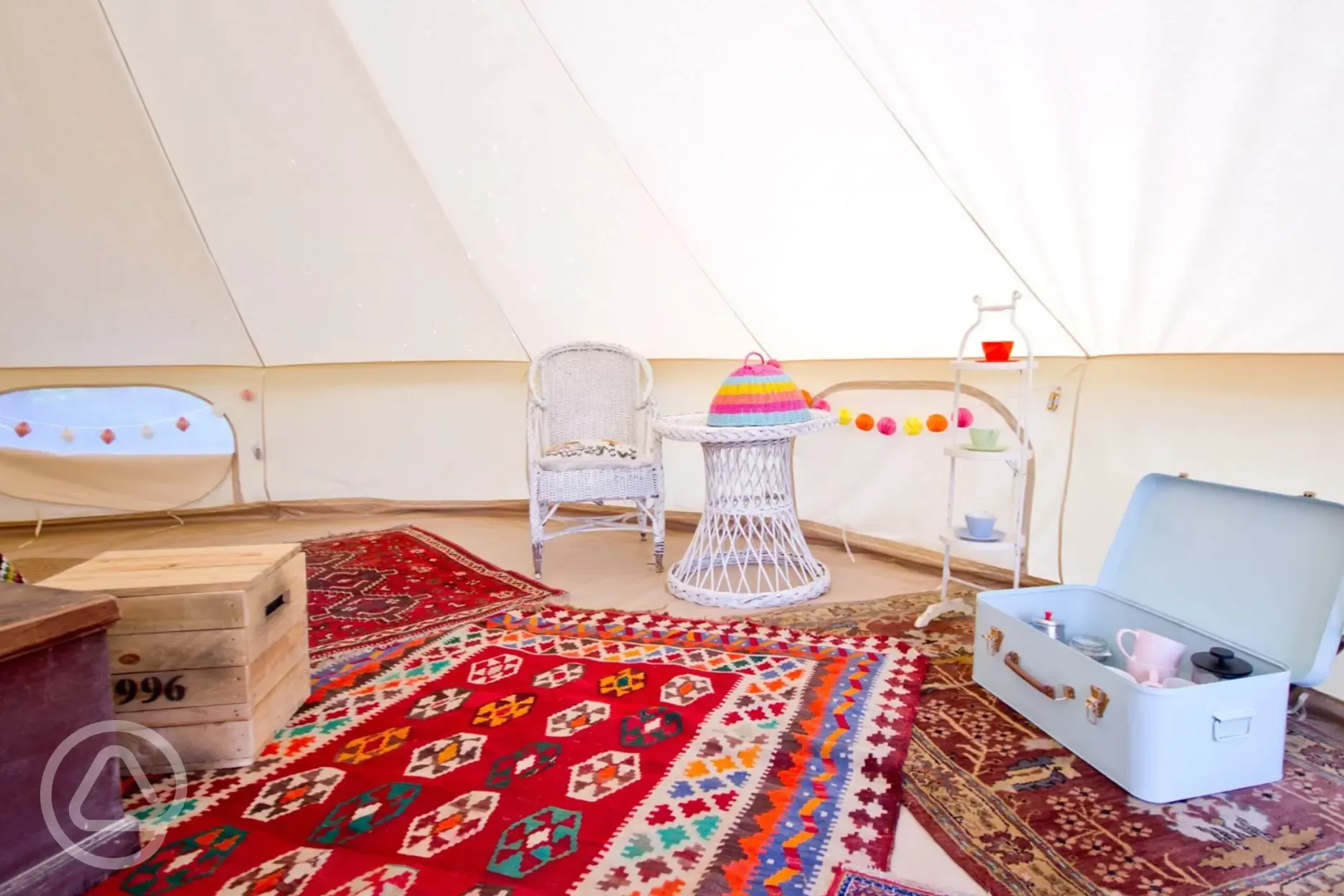 Bell tent furnished interior with a trunk of cooking equipment