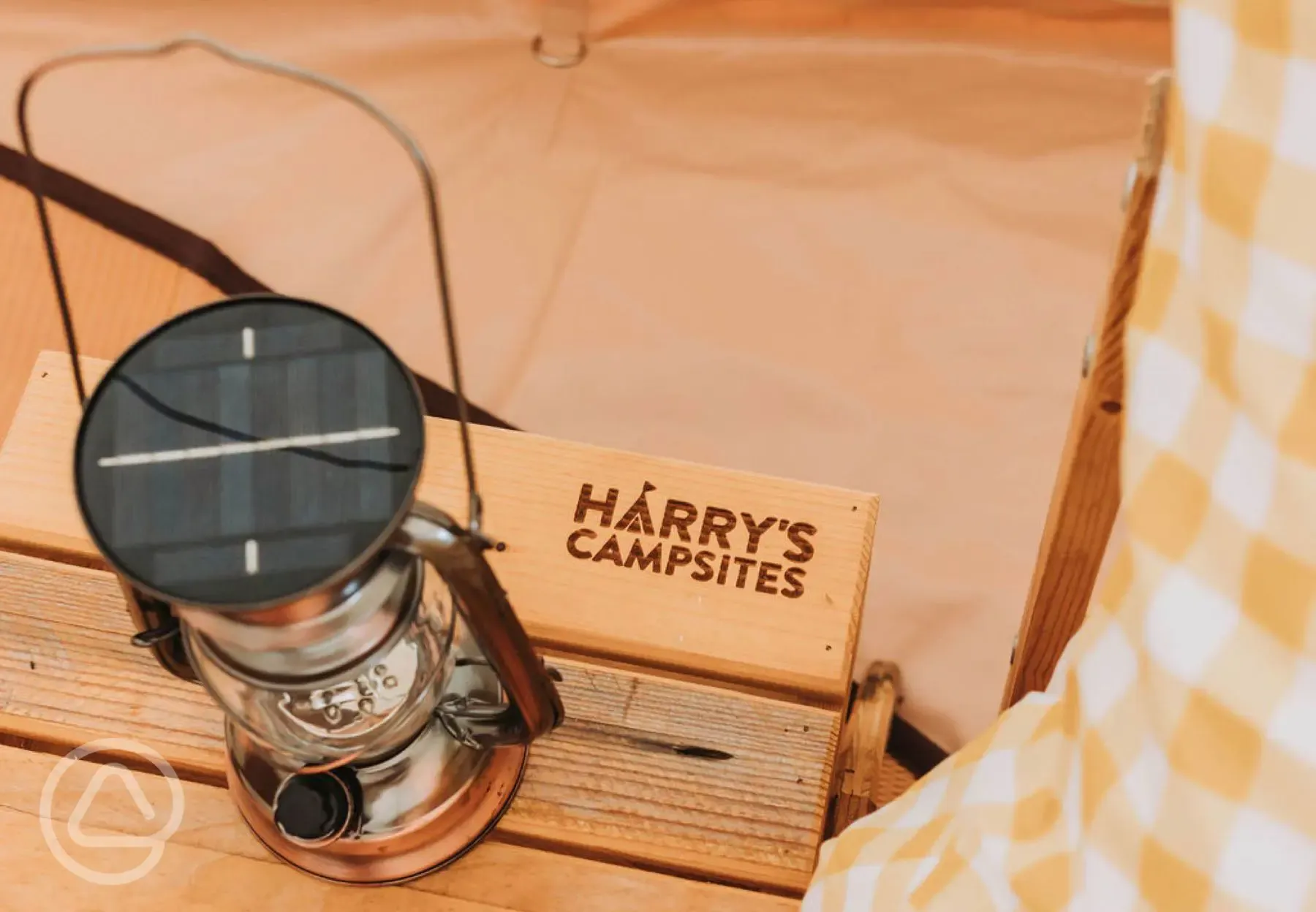 Bell tent bedside table with Harry's Campsites branding