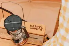 Bell tent bedside table with Harry's Campsites branding