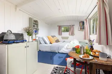 The Shepherd's Hut interior with kitchenette and double bed