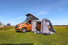 VW campervan on a grass pitch with optional 16 amp hook up