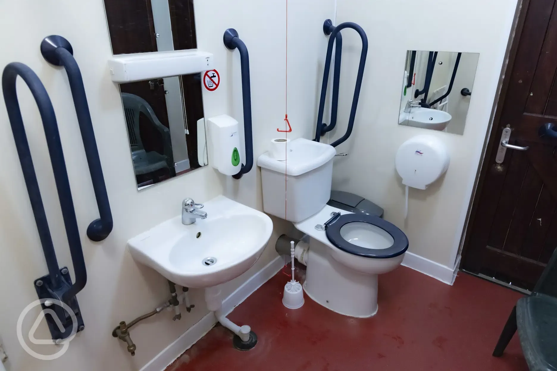 Accessible facilities with handrails, toilet, sink and mirror