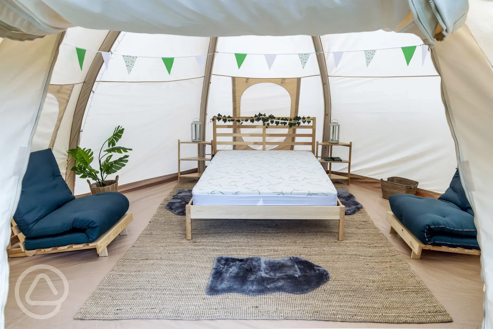 Bell tent interior with double bed and two single sleeping mats