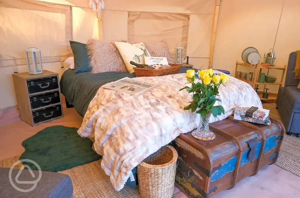Bell tent interior with furnishings and cutlery and crockery for four