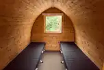 Acorn camping pod featuring two single camping beds (no bedding)