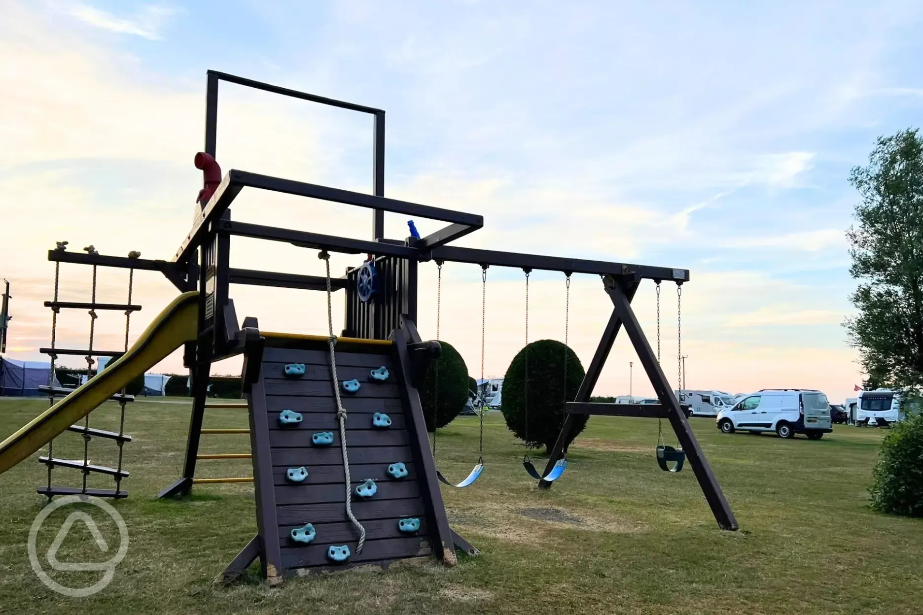 Play park with swings, a slide, climbing wall, rope and step ladder