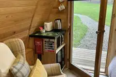 Really cosy ensuite glamping pod with a kitchen corner and sofa chair