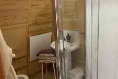 Cosy ensuite with a toilet, shower, and handwashing sink Cosy ensuite with a toilet, shower, and handwashing sink