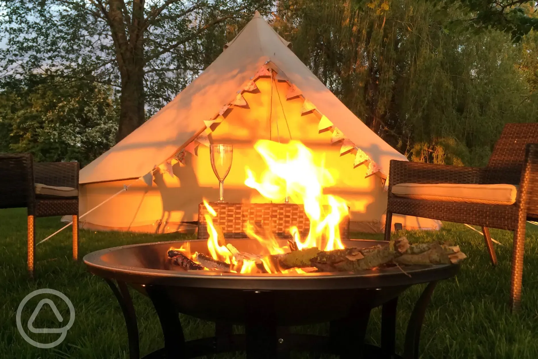 Bell tent exterior alongside a roaring fire in your own personal fire pit
