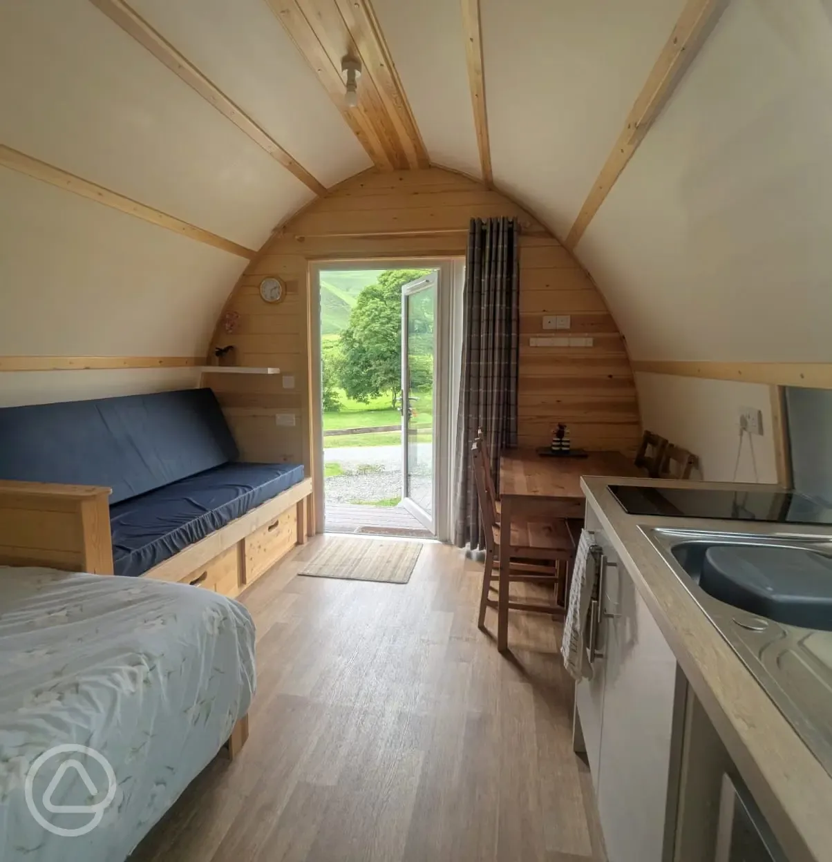 Glamping pod interior with sofa, dining space and countryside views Glamping pod interior with sofa, dining space and countryside views