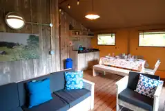 Safari tent lounge and dining area with a kitchenette Safari tent lounge and dining area with a kitchenette