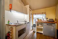 Safari tent equipped kitchen with oven, fridge, toaster and kettle