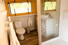 Safari tent ensuite bathroom with shower, toilets, sink and heated towel rail