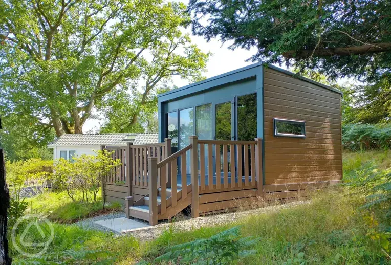 Hideaway ensuite glamping pod with a small deck area and surrounding trees