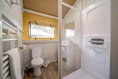 Safari tent ensuite bathroom with toilet, shower, sink and heated towel rail