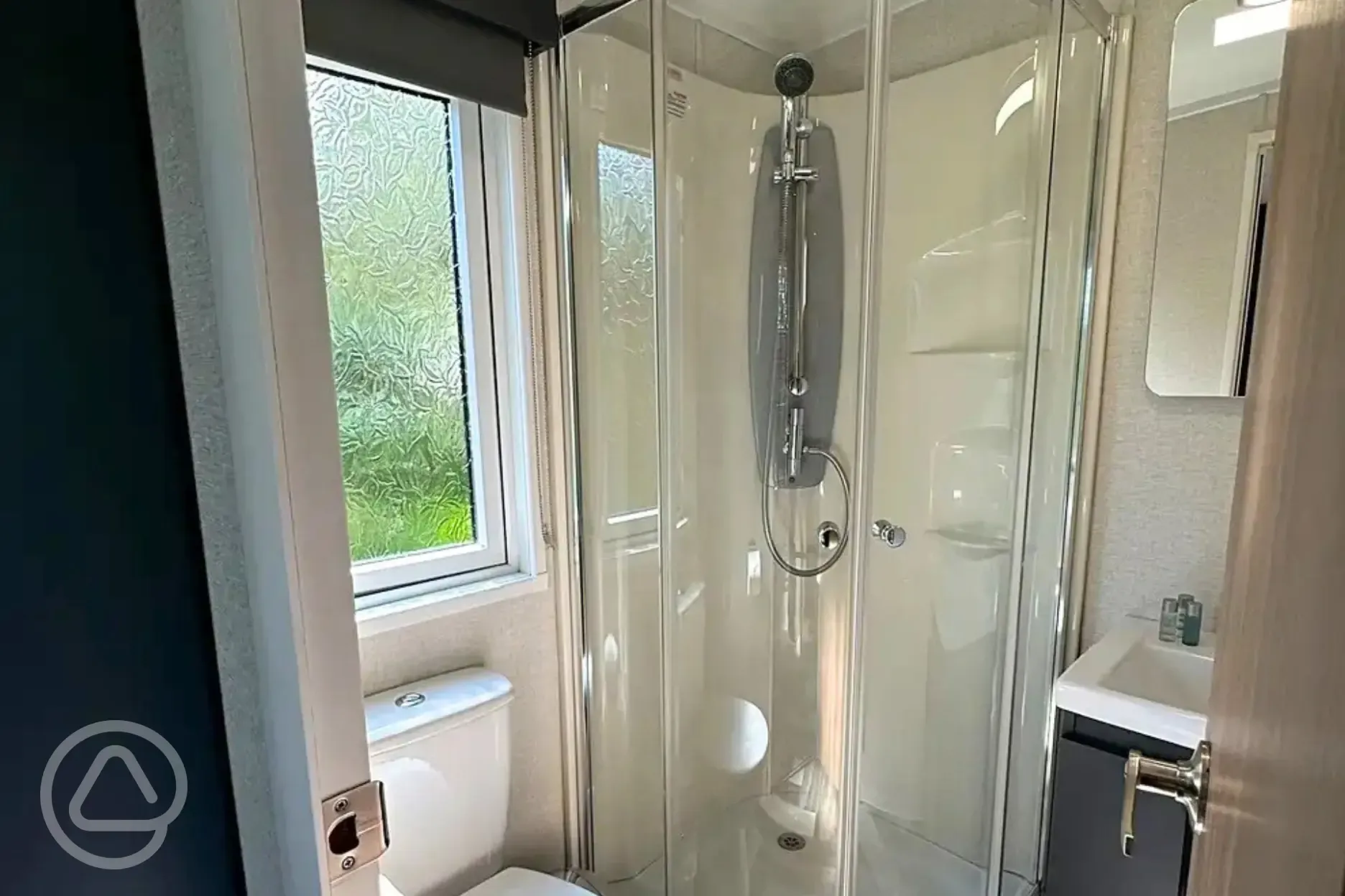 Hideaway pod ensuite bathroom with a toilet, shower, sink and towels