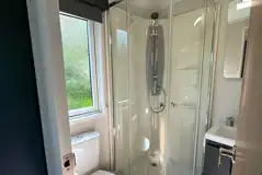 Hideaway pod ensuite bathroom with a toilet, shower, sink and towels