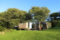 Tawny shepherd's hut exterior with a covered outdoor kitchen