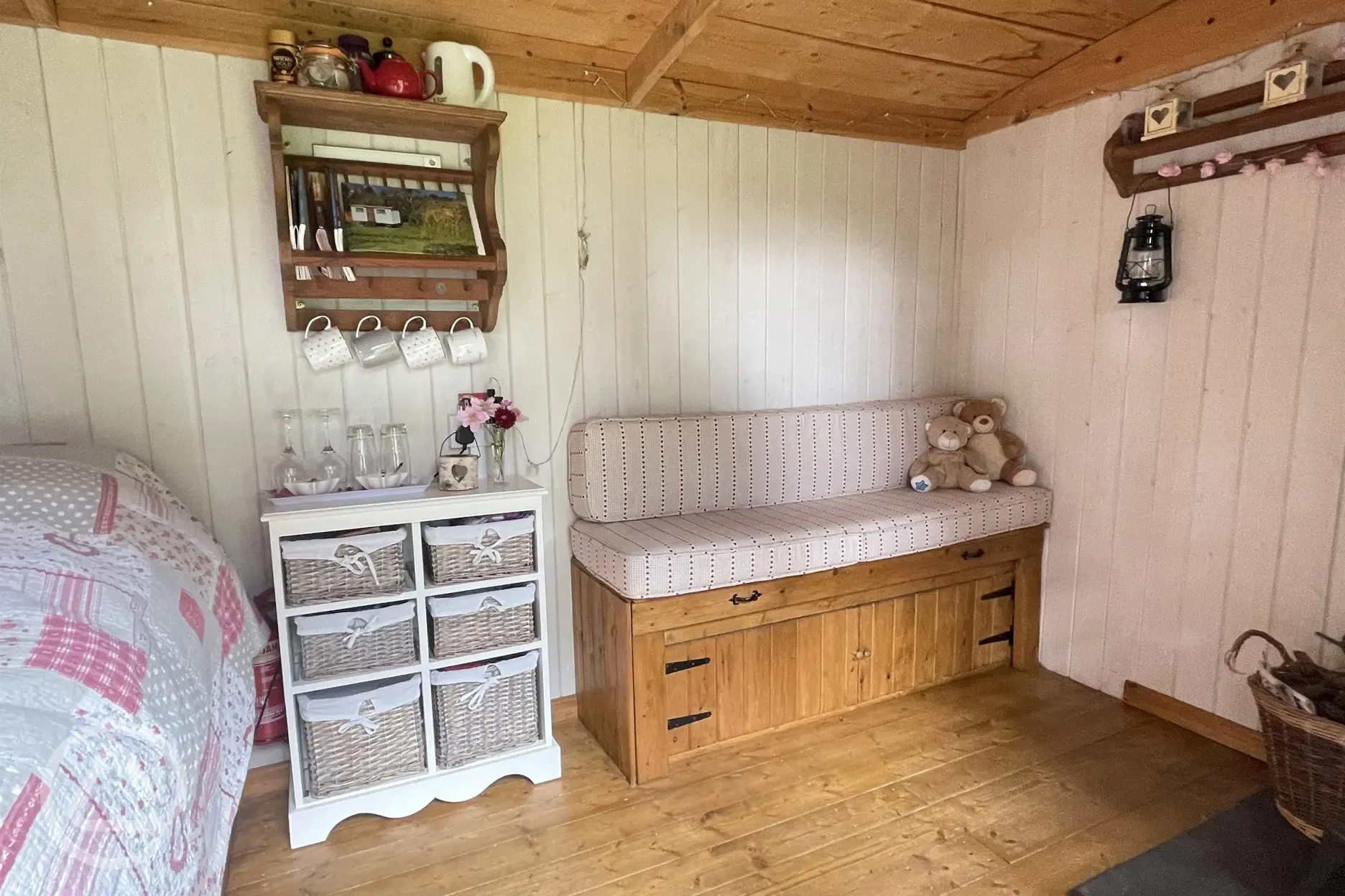Shepherds hut interior showing bench seat which can be pulled out wider for a child to sleep on