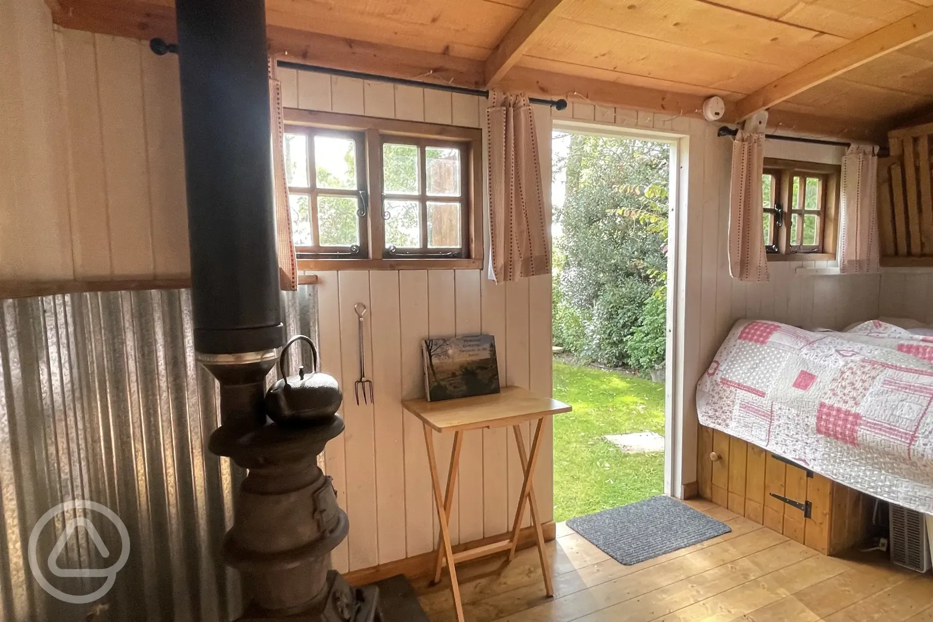 Shepherds hut interior looking out on to picnic bench on the grass outside