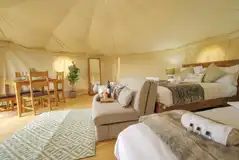 Yurt interior with a double bed and two single beds Yurt interior with a double bed and two single beds