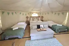 Yurt interior with a double bed and two single beds Yurt interior with a double bed and two single beds