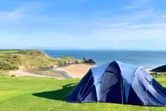 Sea view grass camping pitches at Three Cliffs Bay Holiday Park