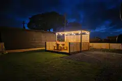 Fully serviced hardstanding pitch with hot tub at night
