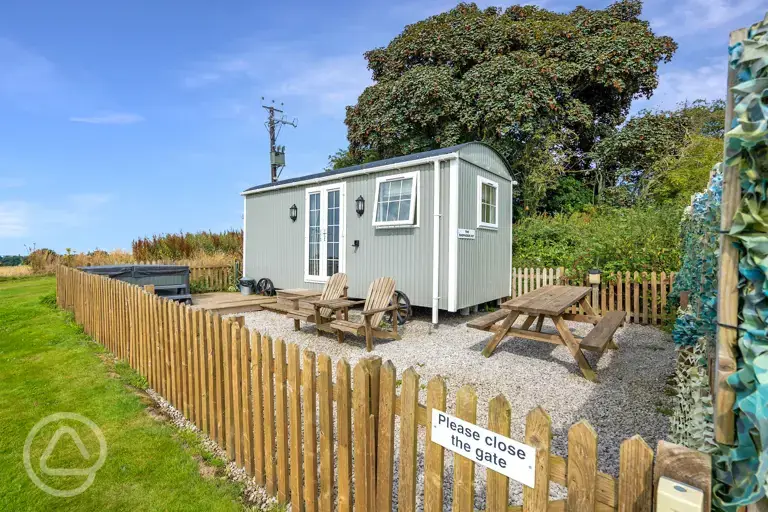 The hut with a gated garden area, seating and electric hot tub