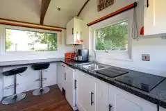 Woodland hut kitchen with a fridge, microwave, air fryer, dishwasher and more