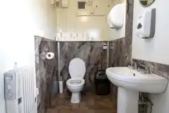 Toilet cubicle with a hand basin and radiator
