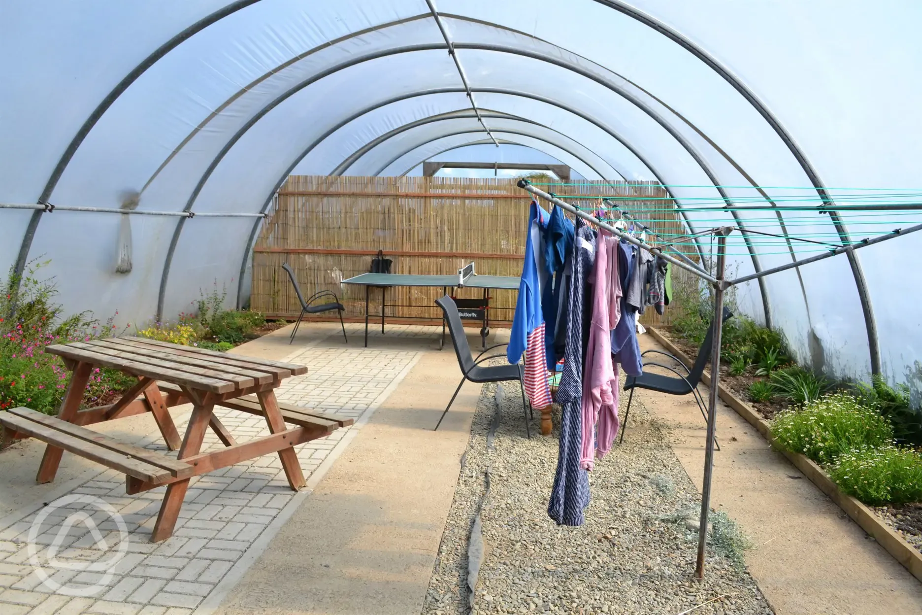 Campers polytunnel space with table tennis and washing line
