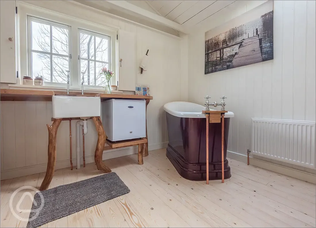 Wee Tree Howf Treehouse interior with a kitchen and slipper bath