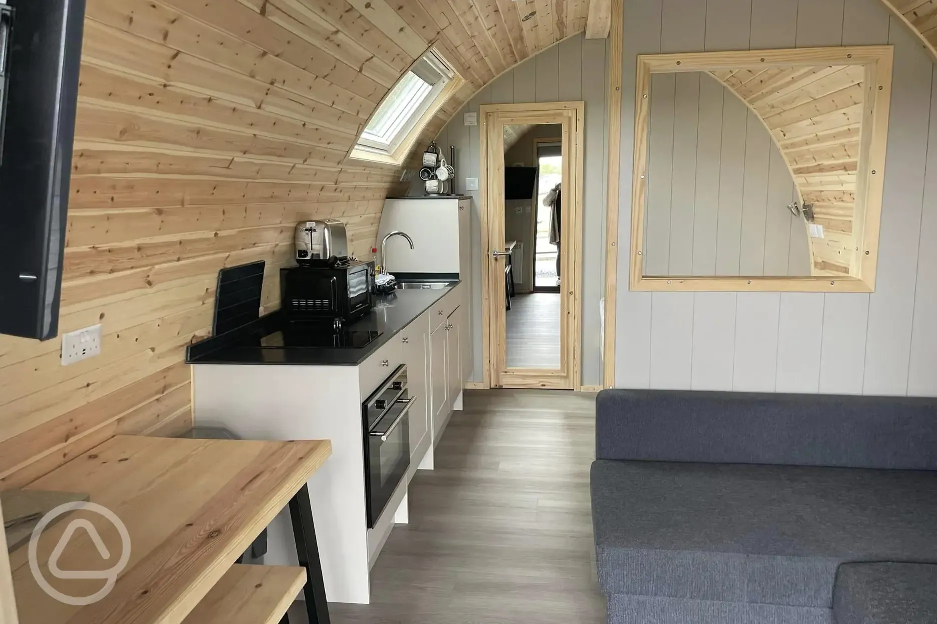 Mega ensuite glamping pod interior with a sofa bed, double bed and kitchen