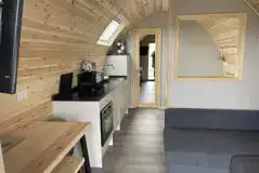 Mega ensuite glamping pod interior with a sofa bed, double bed and kitchen Mega ensuite glamping pod interior with a sofa bed, double bed and kitchen