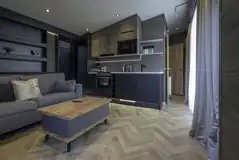 Glamping S-pod living area with sofa, kitchen and TV