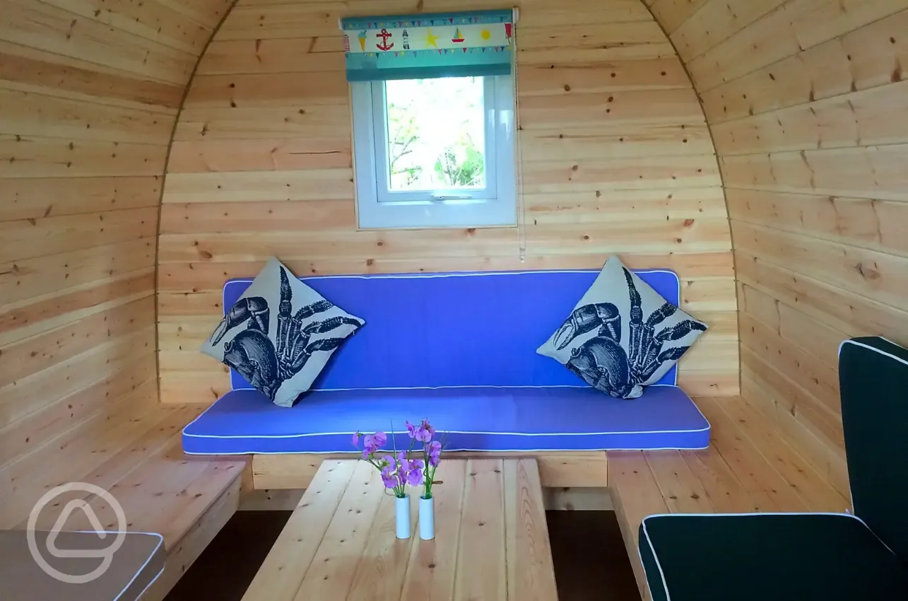 Camping pod (four person) interior with wrap around seating converting into beds