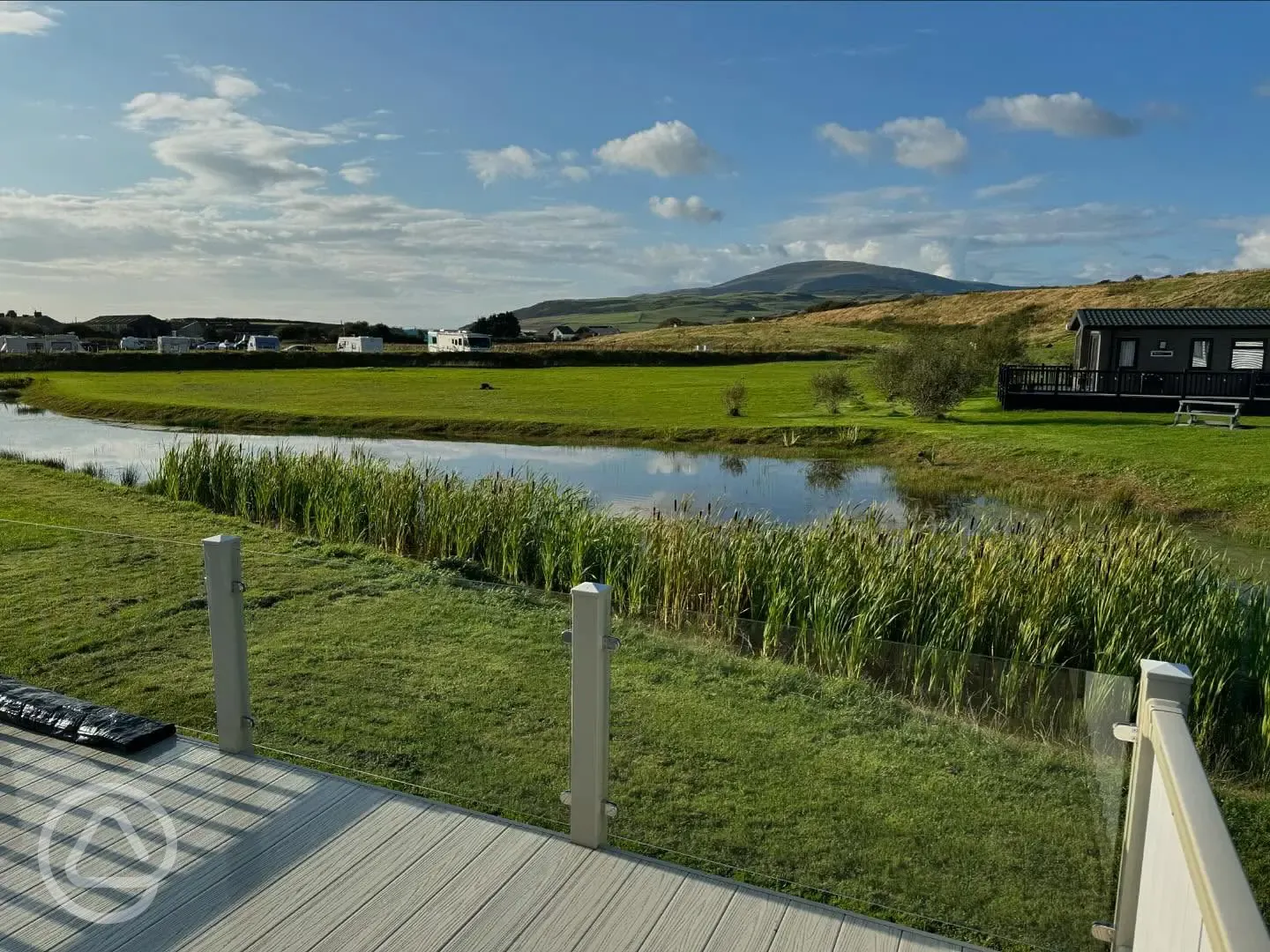 Pitches and glamping units overlooking Harbour Lights' pond